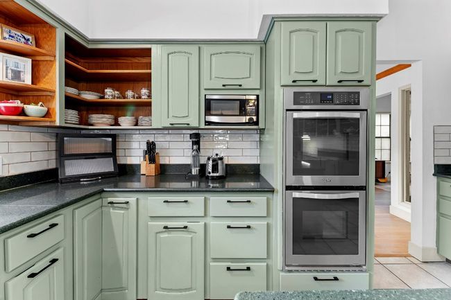 Kitchen featuring green cabinetry, appliances with stainless steel finishes, tasteful backsplash, and light tile patterned floors | Image 14