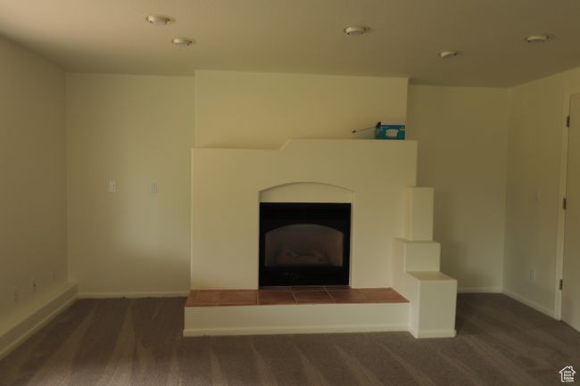 Unfurnished living room with carpet floors and a fireplace | Image 14