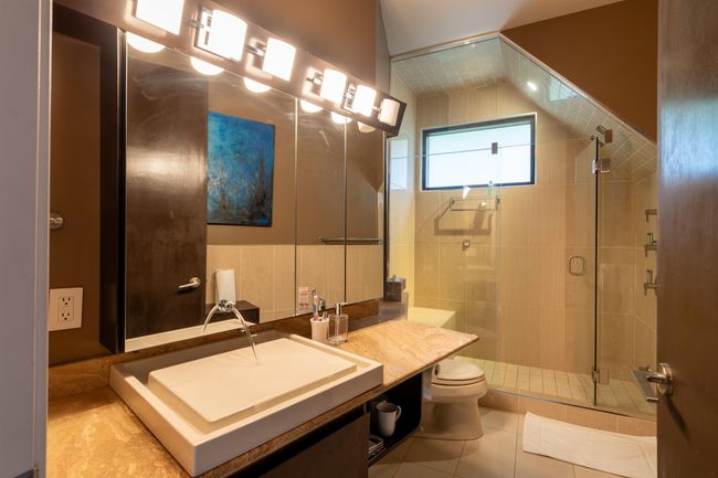 Bathroom with toilet, vanity, a shower stall, and tile patterned flooring | Image 29