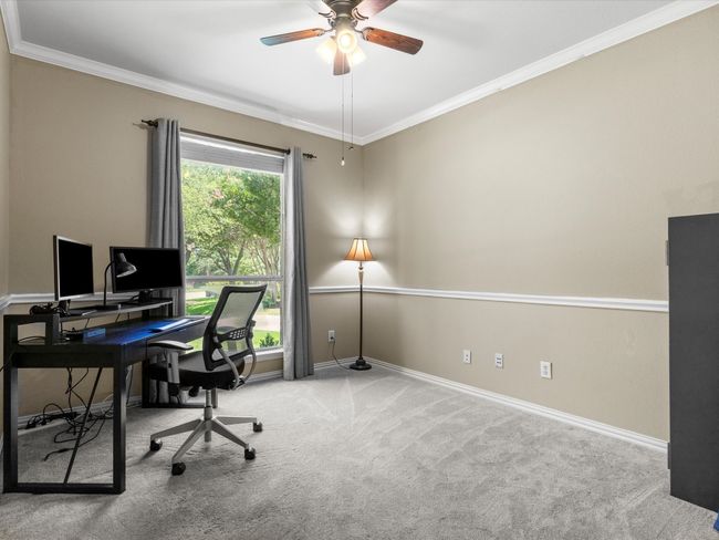 Carpeted office space featuring a ceiling fan and ornamental molding | Image 23