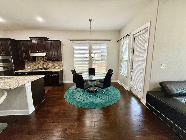 Dining room featuring dark wood-type flooring, baseboards, a chandelier, and recessed lighting | Image 6