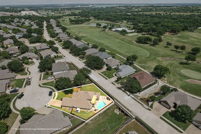 Aerial overview of property's location with a nearby body of water, a golf course, property parcel outlined, and nearby suburban area | Image 34
