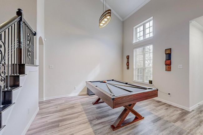 Playroom featuring ornamental molding, a high ceiling, light wood finished floors, billiards, and arched walkways | Image 19