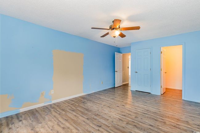 Unfurnished bedroom featuring baseboards, a ceiling fan, wood finished floors, and a textured ceiling | Image 25