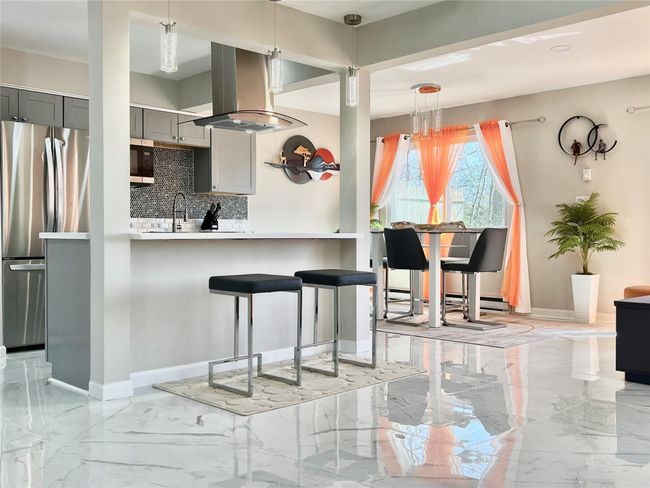 Kitchen featuring gray cabinets, marble finish floor, decorative backsplash, and freestanding refrigerator | Image 21