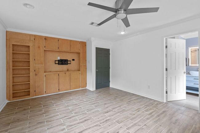 Primary bedroom includes built-ins with a secret door to expansive closet/dressing room. | Image 19
