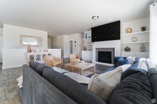 Living room featuring baseboards, wood finished floors, and a fireplace | Image 7