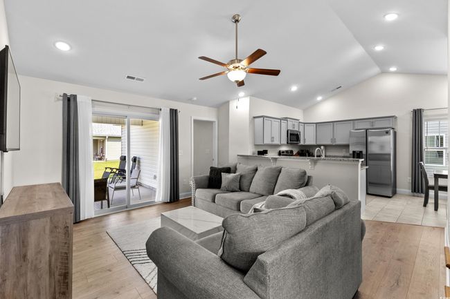 Living room with ceiling fan, light wood-style flooring, recessed lighting, and high vaulted ceiling | Image 16