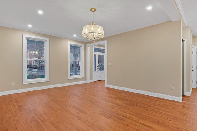 Spare room featuring light wood-type flooring, ornamental molding, and a chandelier | Image 11