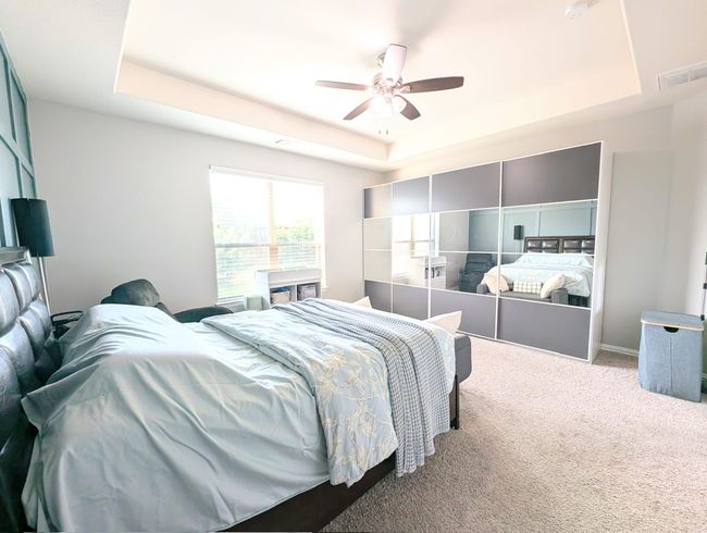 Carpeted bedroom featuring a tray ceiling and a ceiling fan | Image 35