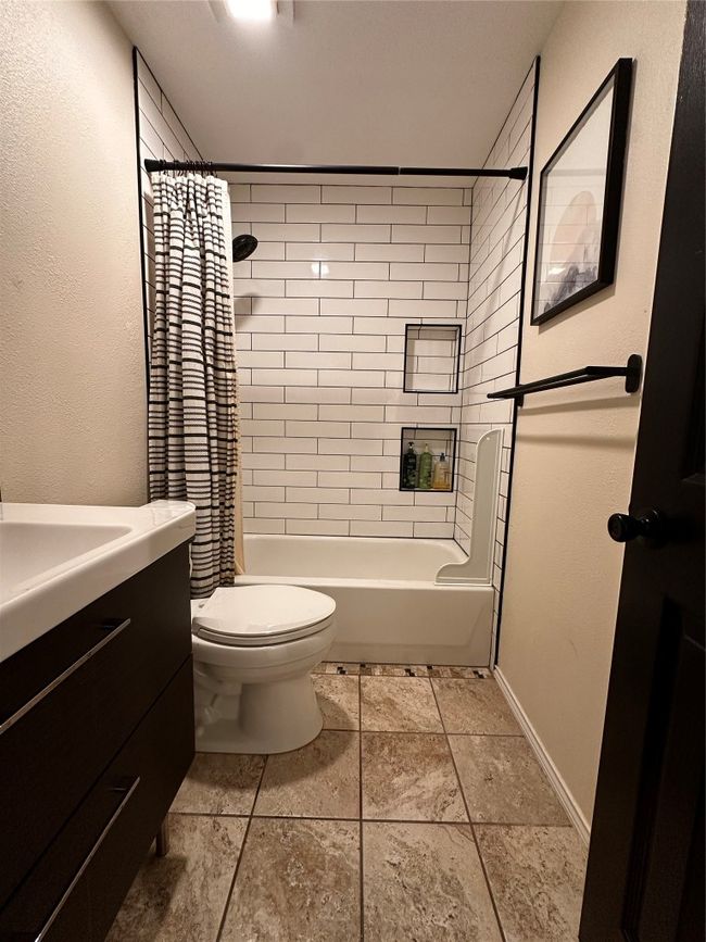 Full bath with toilet, shower / bathtub combination with curtain, vanity, and baseboards | Image 18