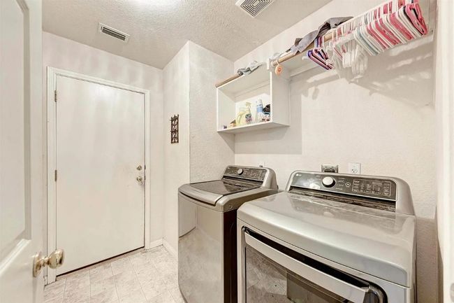 Laundry area featuring washer and dryer and a textured ceiling | Image 14