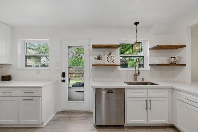 Floating shelves provide both practical storage and a minimalist design element to this renovated space. | Image 12