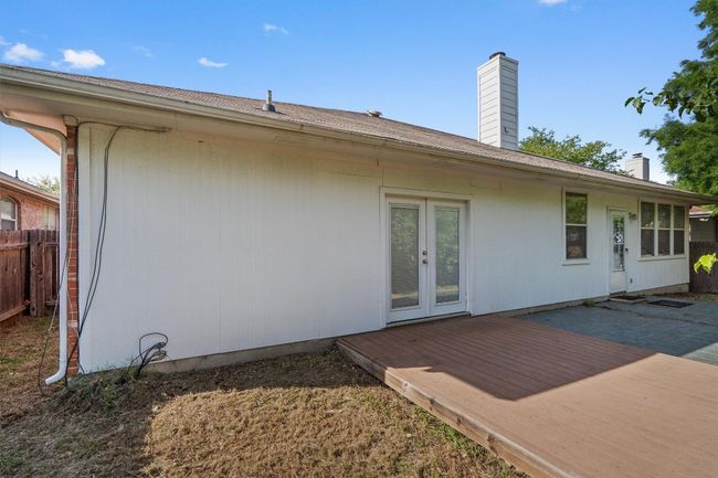 Rear view of property featuring french doors, a chimney, fence, and a wooden deck | Image 34