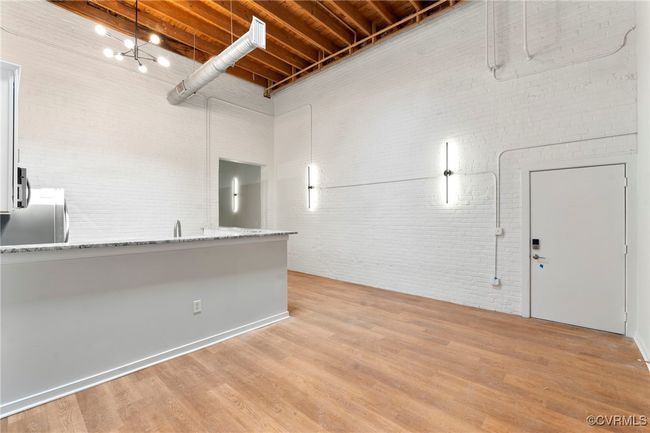 Below grade area featuring brick wall, light wood-style flooring, and freestanding refrigerator | Image 6