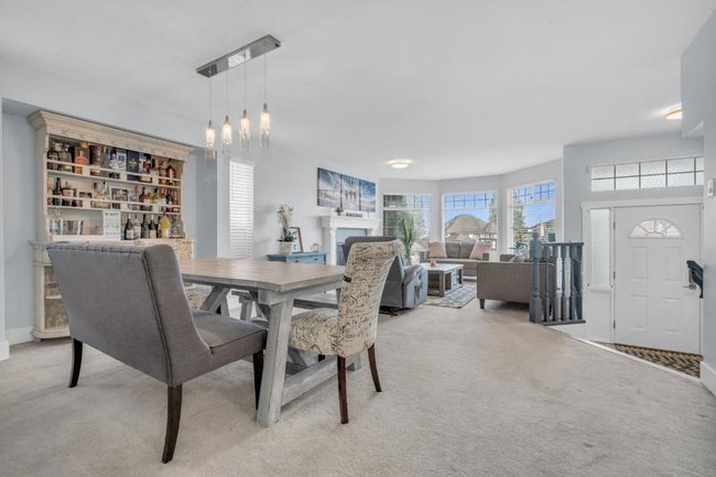 Dining space featuring light colored carpet, a fireplace, and an inviting chandelier | Image 8