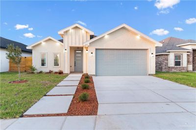 View of front of home featuring a front lawn and a garage | Image 1