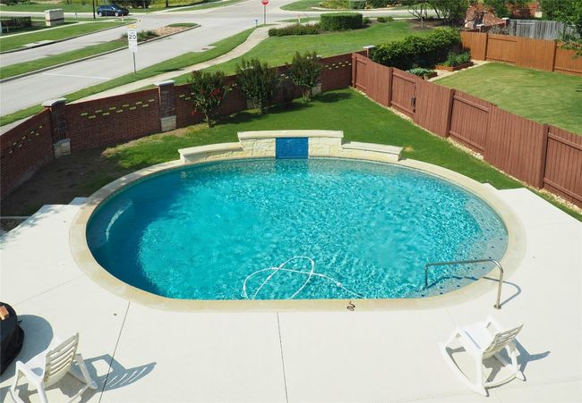 View of swimming pool with a fenced backyard | Image 6