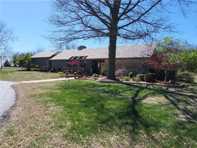 View of front facade with stone siding, a chimney, and a front yard | Image 70
