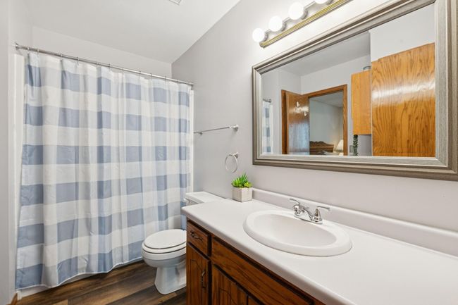 The full upper level walk-thru bathroom features a bath/shower combination and LVP flooring | Image 13