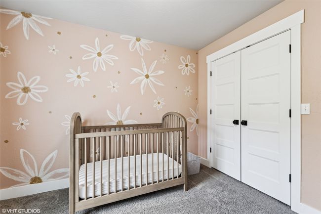 Carpeted bedroom with wallpapered walls, a closet, and a nursery area | Image 19