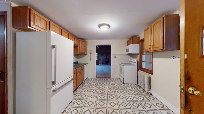 Kitchen featuring white appliances and radiator heating unit | Image 7