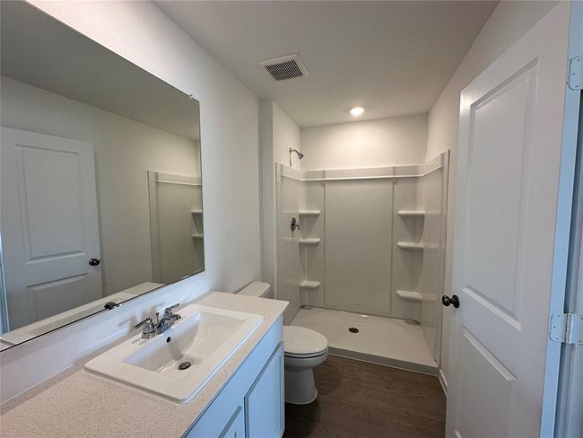 Full bathroom featuring wood finished floors, a stall shower, and vanity | Image 16