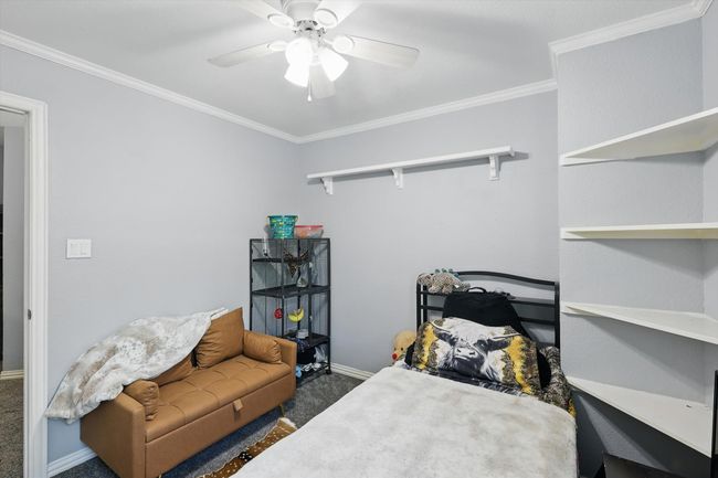 Carpeted bedroom with crown molding and a ceiling fan | Image 24