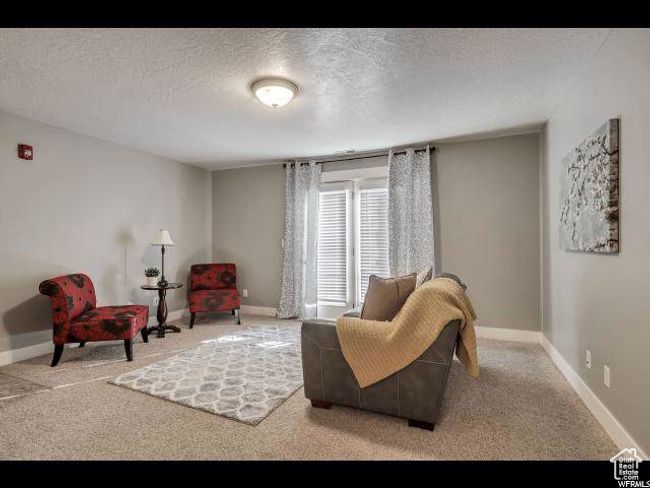 Sitting room with carpet flooring, baseboards, and a textured ceiling | Image 6