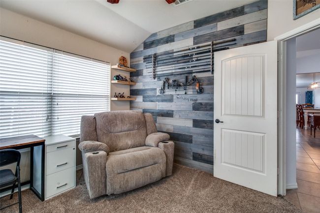 Living area with lofted ceiling, wood walls, carpet floors, and tile patterned flooring | Image 12