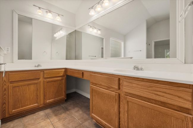 Primary bath features double vanity, vaulted ceiling, and ceramic tile floors | Image 14