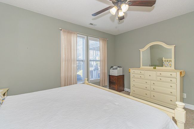 Bedroom with ceiling fan, carpet, and a textured ceiling | Image 17