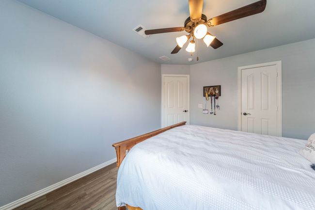 Bedroom featuring dark wood finished floors, baseboards, and a ceiling fan | Image 20