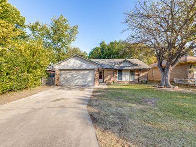 Ranch-style home with a garage and a front lawn | Image 1