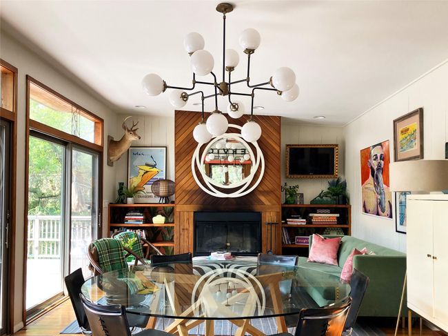 Dining area with a chandelier, wooden walls, a large fireplace, and wood finished floors | Image 5