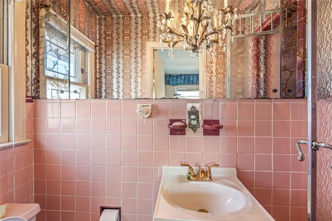 Bathroom featuring a sink, a notable chandelier, and tile walls | Image 9