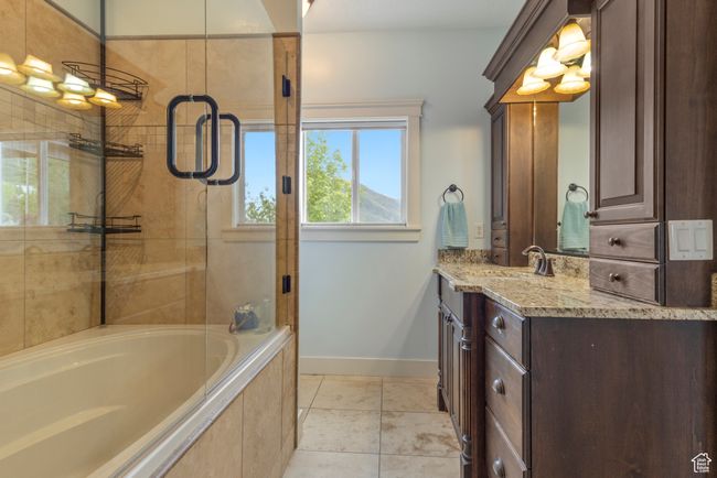 Bathroom featuring baseboards, a tile shower, vanity, a relaxing tiled tub, and tile patterned floors | Image 19