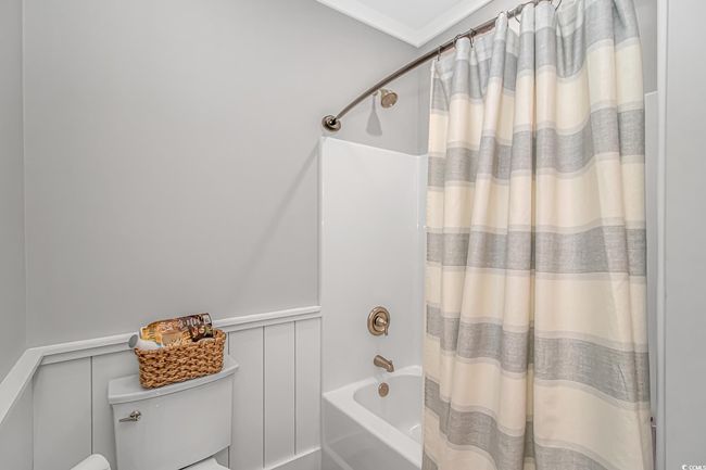 Full bath with shower / tub combo, wainscoting, and a decorative wall | Image 16