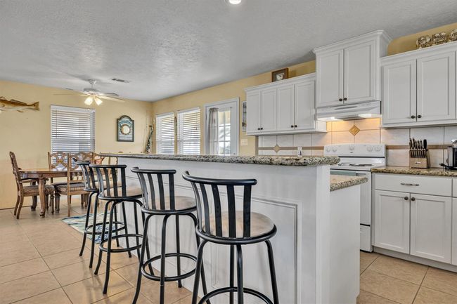 The kitchen island is split level providing a large breakfast/serving bar. | Image 12