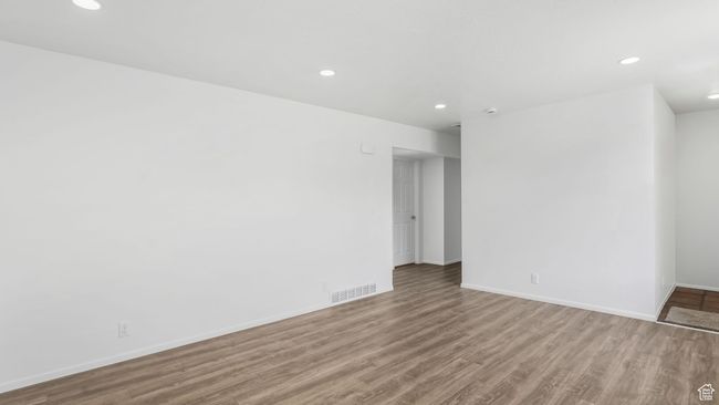 Unfurnished room featuring recessed lighting, visible vents, wood finished floors, and baseboards | Image 5