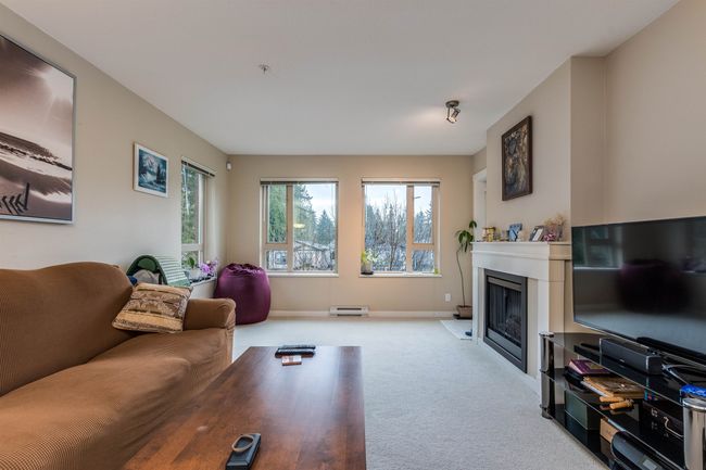 Carpeted living area featuring baseboards and a fireplace | Image 9