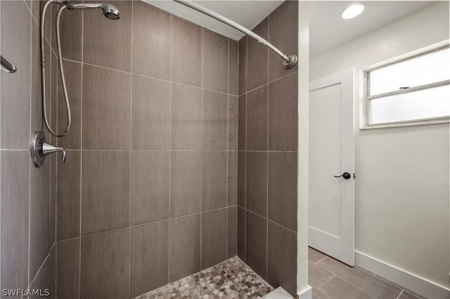 Bathroom with a tile shower and tile patterned flooring | Image 30