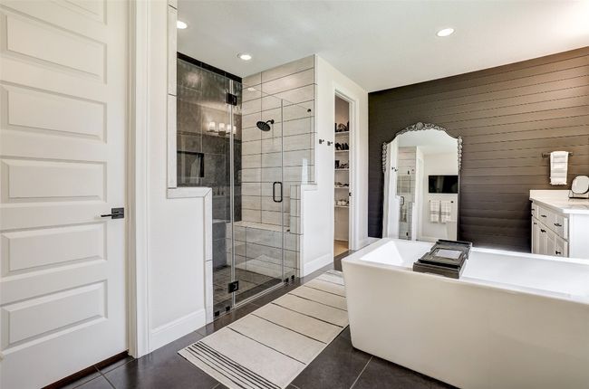 Bathroom featuring a spacious closet, a shower, tile a freestanding tub, and vanity | Image 16