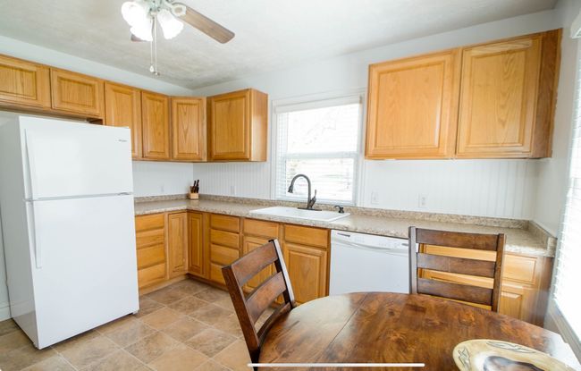 Kitchen featuring white appliances, a sink, light countertops, and ceiling fan | Image 5
