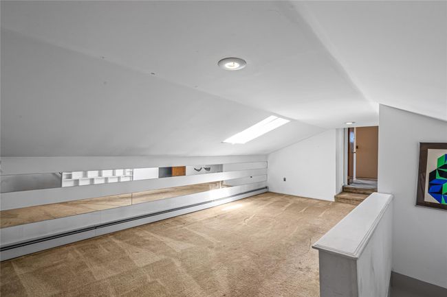 Bonus room featuring carpet floors, vaulted ceiling with skylight, and a baseboard heating unit | Image 14