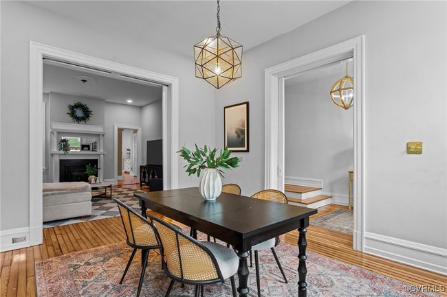 Dining area featuring hardwood / wood-style floors, baseboards, a fireplace, and a notable chandelier | Image 6