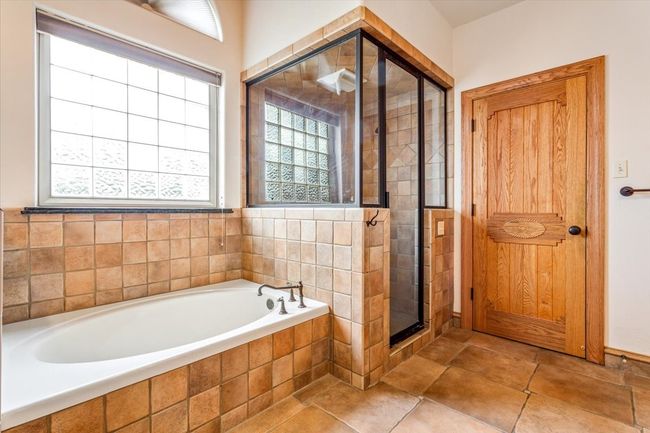 Full bath featuring a stall shower, a bath, and tile patterned floors | Image 21