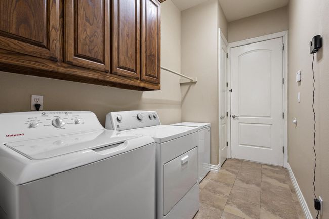 Large laundry, cabinets, storage closet and entry door from garage. | Image 30