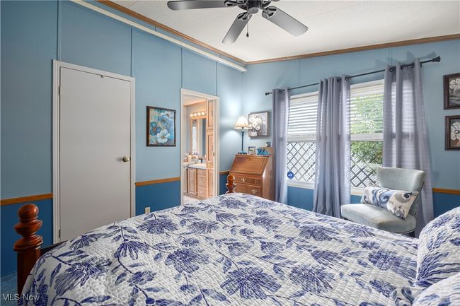 Bedroom with crown molding, ceiling fan, and ensuite bath | Image 35