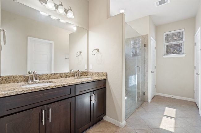 Relax in the en-suite bathroom with dual vanities and an oversized walk-in shower. | Image 11